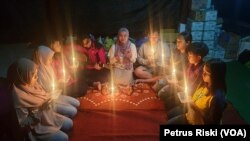 Famirza (tengah), remaja asa Desa Bulukerto di Kota Batu, Jawa Timur, membacakan puisi pada malam renungan untuk pemulihan trauma bagi anak dan remaja korban banjir Bulukerto pada 12 November 2021. (Foto: VOA/Petrus Riski)