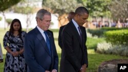 El presidente Barack Obama y su predecesor, George W. Bush, honran en silencio a las víctimas de un ataque a la embajada estadounidense en Tanzania, en 1998.