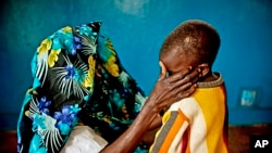 A mass rape victim comforts her son in the town of Fizi, Congo, Feb. 20, 2011. 