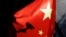 FILE — A surveillance camera is silhouetted behind a Chinese national flag in Beijing, China, Nov. 3, 2022.