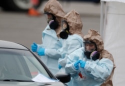 Colorado National Guard medical personnel perform coronavirus test on a motorist at a drive-through testing site outside the Denver Coliseum Saturday, March 14, 2020, in Denver. Officials planned to administer 150 tests but the line of vehicles…