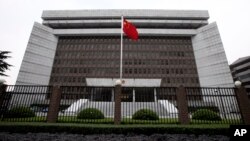 FILE - A Chinese national flag flutters in front of the Shanghai's No. 1 People's Intermediate Court in Shanghai, China.