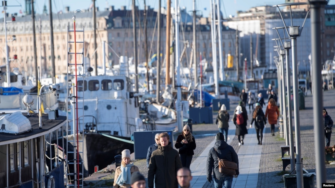 Warga swedia menikmati cuaca cerah di musim dingin dengan berjalan-jalan di sepanjang dermaga Standvagen, di tengah pandemi COVID-19 yang terus meningkat di Stockholm, Swedia, 20 November 2020. 
