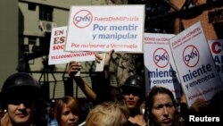 Supporters of Venezuela's President Nicolas Maduro hold placards during a gathering to support Maduro’s government order of suspension of CNN's Spanish-language service outside the National Commission of Telecommunications (CONATEL), in Caracas, Venezuela, Feb. 16, 2017. 