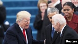 El presidente Donald Trump saluda al exvicepresidente Joe Biden durante su toma de posesión frente al Capitolio, en Washington, el 20 de enero de 2017.