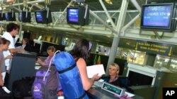 FILE - Passengers en route to London check in at Biarritz airport, southwestern France, Aug. 11, 2006. The U.S. is expected to broaden its ban on in-flight laptops and tablets to include planes from the European Union. 