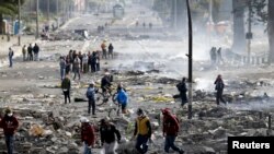 El público camina entre los restos de barricadas levantadas en Quito por manifestantes en las protestas del 3 al 13 de octubre de 2019.