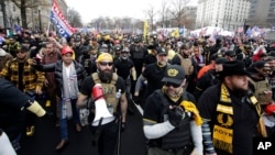 FILE - Supporters of then-President Donald Trump, wearing attire associated with the Proud Boys, attend a rally at Freedom Plaza, Dec. 12, 2020, in Washington. 