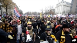 FILE - Supporters of then-President Donald Trump, wearing attire associated with the Proud Boys, attend a rally at Freedom Plaza, Dec. 12, 2020, in Washington. 