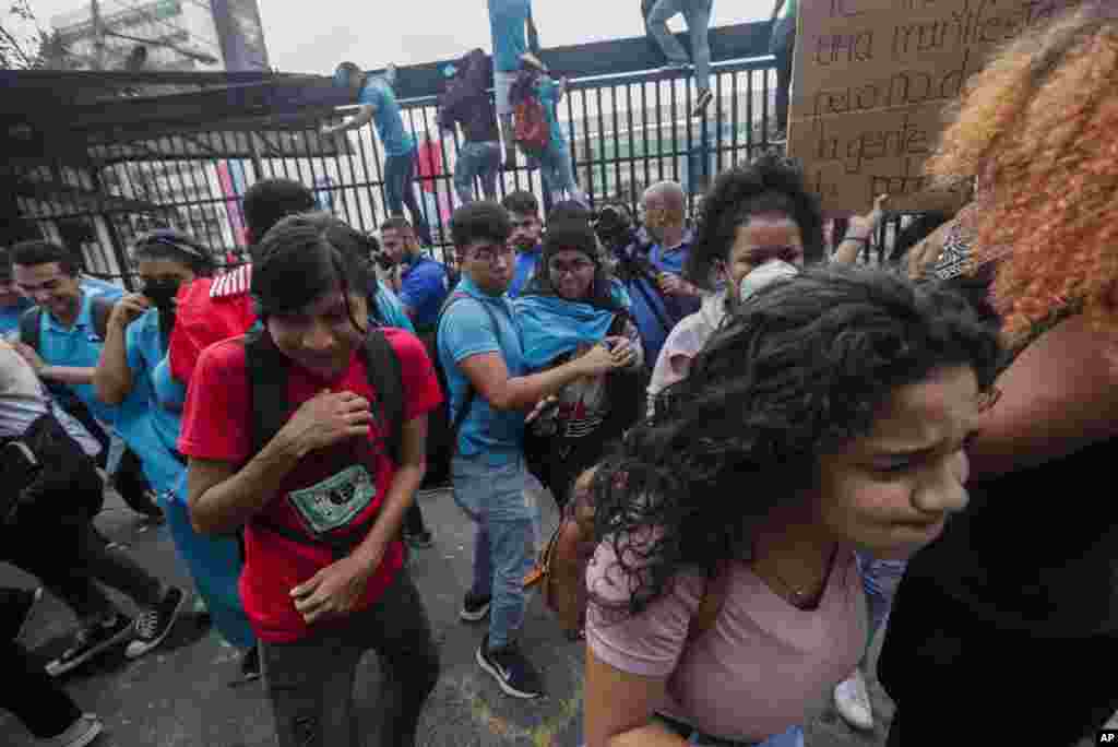 Los manifestantes huyen de gases lacrimógenos disparados por la policía desde los terrenos de la Asamblea Nacional. 