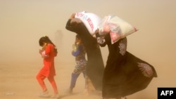 Orang Irak yang mengungsi di tengah operasi pemerintah melawan kelompok IS di Fallujah membawa kebutuhan pangan dasar yang disaumbangkan oleh sebuah LSM, Preemptive Love Coalition. Khaldiyeh, Irak. (Foto: AFP PHOTO / Haidar Mohammed Ali)