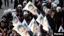 FILE - Demonstrators hold flags with pictures of imprisoned Kurdish rebel leader Abdullah Ocalan, during a protest against latest security operations in Diyarbakir, Turkey, Sept. 6, 2015.