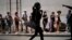 People wait in line to buy food amid concerns about the spread of COVID-19, in downtown Havana, Cuba, April 3, 2020. 