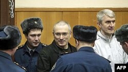 Mikhail Khodorkovsky, giữa, và Platon Lebedev, phải, được hộ tống đến một phòng xử án ở Moscow, 27/12/2010