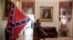 A supporter of President Donald Trump carries a Confederate battle flag on the second floor of the U.S. Capitol after breaching security, in Washington, Jan. 6, 2021.
