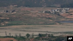 North Korea's Kaepoong town is seen behind a North Korean military guard post, bottom, from the unification observatory in Paju, South Korea, May 6, 2019. North Korea says it is suffering its worst drought in decades amid concern of a food crisis..
