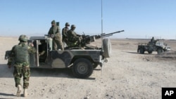 Afghan National Army soldiers guard at a checkpoint on the way to the Sangin district of Helmand province, Afghanistan, Dec. 23, 2015. 