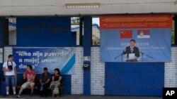 FILE - Workers rest near billboard showing Chinese President Xi Jinping, reading: "Welcome President", right, and billboard reading: "Nobody was hurt in my shift today" in front of the Zelezara Smederevo steel mill, in the city of Smederevo, 45 kilometers east of Belgrade, Serbia, June 29, 2017. When U.S. Steel sold its loss-making smelter in Serbia to the government for $1 in 2012, few thought the communist-era factory would ever be revived. 