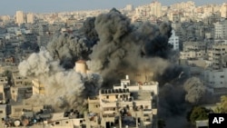 El humo se levanta de una explosión causada por un ataque aéreo israelí en un edificio del centro cultural Said al-Mis'hal en la ciudad de Gaza, el jueves 9 de agosto de 2018. Funcionarios palestinos dicen que aviones de combate israelíes atacaron el centro cultural en la ciudad de Gaza. El Ministerio de Salud palestino dice que siete transeúntes resultaron heridos en el ataque aéreo del jueves por la noche en el campo de refugiados de Shati. (AP Photo / Arafat Kareem)