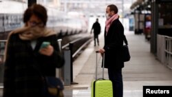 A man wearing a protective face mask waits for a train at Gare du Nord railway station in Paris after French President ordered stringent restrictions on people's movement to slow the spread of the coronavirus disease (COVID-19), France, March 17, 2020.