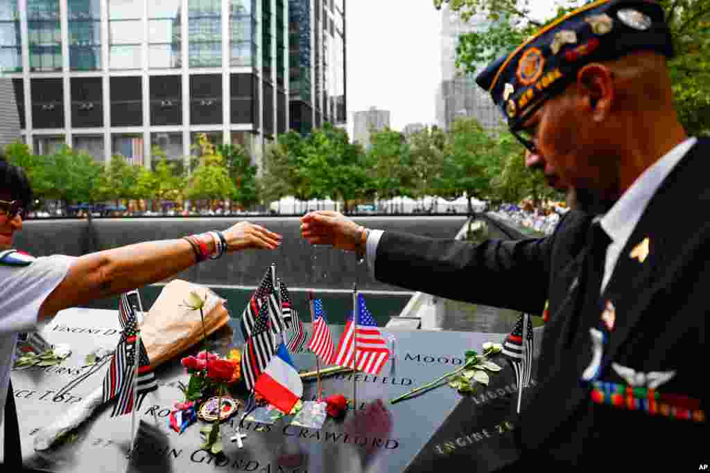 2026년 9월 11일 뉴욕 '국립 9/11 추모관'에서 열린 9·11 테러 25주기 추모식에서 사람들이 희생자 중 한 명인 마이클 저지 신부를 위해 기도하며 손을 맞잡고 있다.