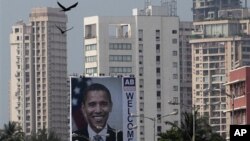 Birds fly past a billboard depicting U.S. President Barack Obama in Mumbai, India, Friday, Nov. 5, 2010. President Obama is scheduled to visit the city during his trip to India.