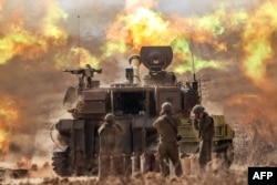 An Israeli army self-propelled howitzer fires rounds near the border with Gaza in southern Israel on Oct. 11, 2023.
