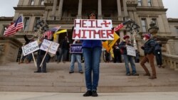 Dawn Perreca protests on the front steps of the Michigan State Capitol in Lansing, April 15, 2020. Protesters are decrying Gov. Gretchen Whitmer's orders to keep people at home and businesses locked during the COVID-19 outbreak.