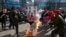 FILE - A member of a South Korean conservative group kicks a burning banner with an image of North Korean leader Kim Jong Un and North Korean flags during a rally denouncing the North, in Paju, South Korea, Jan. 11, 2016.
