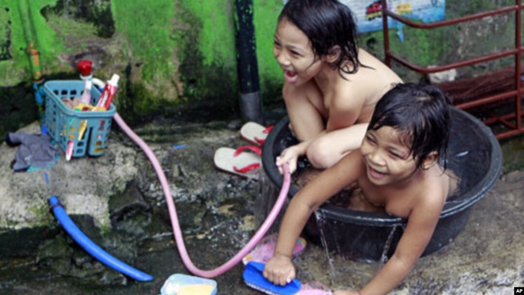 Informal settlers play while bathing on a tub in San Juan, Manila. The Philippines is expected to sustain post-crisis economic growth, but this will be without development which may increase poverty, according to a new study from the United Nations, May 2