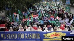 Orang-orang membawa poster dan meneriakkan slogan-slogan selama pawai 'Freedom March' untuk mengekspresikan solidaritas dengan rakyat Kashmir, di Lahore, Pakistan, 6 Oktober 2019. (Foto: Reuters/Mohsin Raza)