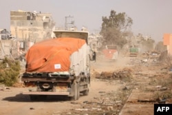 Kendaraan pengangkut bantuan kemanusiaan melaju di sepanjang jalan Salaheddine di distrik Zeitoun di pinggiran selatan Kota Gaza pada 26 November 2023. (Foto: AFP)