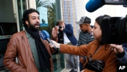 FILE - Moroccan journalist and activist Omar Radi speaks to the media after his hearing at the Casablanca Courthouse, In Casablanca, Morocco, March 5, 2020.