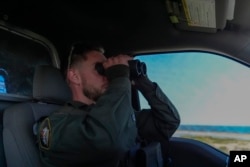 Conservation officer Sgt. Ian Van Nest scans the area for polar bears, Tuesday, Aug. 6, 2024, in Churchill, Manitoba. (AP Photo/Joshua A. Bickel)