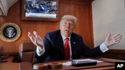 President Donald Trump, on board Air Force One, gestures while watching a live television broadcast of the Senate confirmation vote of Supreme Court nominee Brett Kavanaugh, Oct. 6, 2018. Trump was traveling from Washington to Topeka, Kan., for a campaign rally.