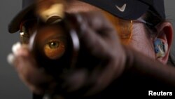 Shooting competitor Kim Rhode looks down the barrel of her shotgun as she poses for a portrait at the U.S. Olympic Committee Media Summit in Beverly Hills, Los Angeles, California, March 8, 2016.