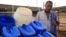 Fresh Life Frontline member Bernard Mutuku stands next to waste collection containers at the processing facility in the industrial area of Nairobi, Kenya, September 11, 2012. (J. Craig/VOA) 