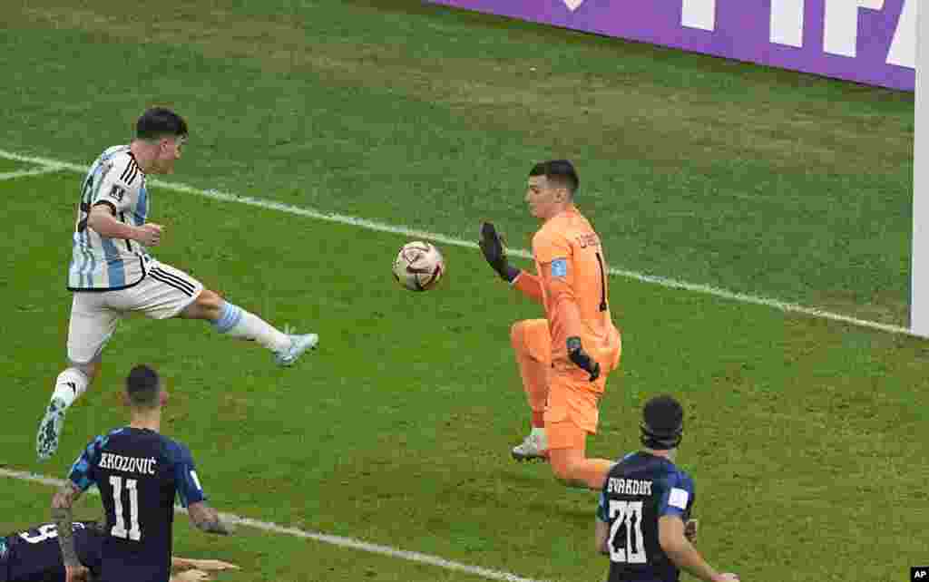 El argentino Julián Álvarez, a la izquierda, anota el segundo gol de su equipo durante el partido de fútbol semifinal de la Copa del Mundo, el martes 13 de diciembre de 2022. (Foto AP/Pavel Golovkin)