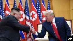 Presiden AS Donald Trump (kanan) dan Pemimpin Korea Utara Kim Jong Un saat bertemu di zona demiliterisasi di Korea Selatan, 30 Juni 2019.