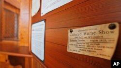 FILE - An advertisement for a "Colored Horse Show" is on display at the Montpelier Train Depot segregation exhibit in Orange, Va., Jan. 27, 2016.