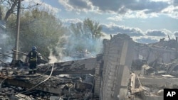 Petugas pemadam kebakaran bekerja untuk memadamkan api setelah serangan roket mematikan Rusia yang menewaskan lebih dari 40 orang di Desa Hroza dekat Kharkiv, Ukraina, Kamis, 5 Oktober 2023. (Foto: via AP)