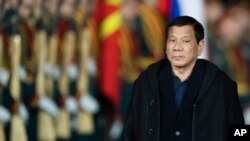 FILE - Philippine President Rodrigo Duterte reviews an honor guard upon his arrival at government airport Vnukovo II just outside Moscow, Russia, May 22, 2017.