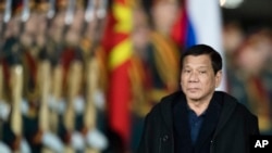 Philippine President Rodrigo Duterte reviews honor guards upon his arrival at government airport Vnukovo II just outside Moscow, Russia, late Monday, May 22, 2017. Due to a spike in violence in the southern Philippines province of Mindanao, Duterte will cut short his visit to Russia, his spokesman said.