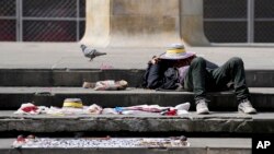 Un vendedor ambulante descansa bajo el sol en la Plaza de Bolívar en Bogotá, Colombia, el martes 25 de octubre de 2022. (Foto AP/Fernando Vergara)