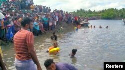 Warga menyaksikan Angkatan Laut Sri Lanka melakukan operasi penyelamatan di dekat lokasi kapal feri yang terbalik di Kinniya, sebelah timur Ibu Kota Kolombo, Sri Lanka, 23 November 2021. (Foto: REUTERS)
