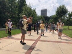 FILE - Protesters march opposing in-person classes at Georgia Tech in Atlanta, Aug. 17, 2020. More of the state public universities are opening for the fall term.