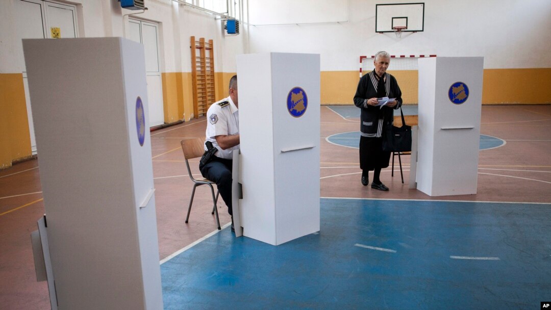 Orang-orang mempersiapkan TPS di Mitrovica yang diominasi oleh Serbia, Kosovo, 8 Juni 2014. 