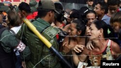 People clash with Venezuelan National Guards as they try to cross the border to Colombia over the Francisco de Paula Santander international bridge in Urena, Venezuela, Dec. 18, 2016.