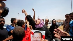 A supporter of former president Hosni Mubarak holds his poster in Cairo, August 22, 2013.