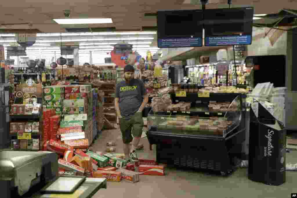 Un trabajador pisa la mercadería que se encuentra dispersa en el piso de una tienda de comestibles de Albertson el sábado 6 de julio de 2019 luego de un terremoto en Ridgecrest, California. El viernes por la noche, con una magnitud de aproximadamente 7.1, sacudió gran parte de California.